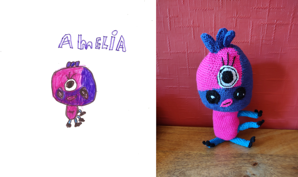 A photo of a drawing of Amelia next to which is the crochet toy. Amelia has a large oval head, the bottom half of which is purple and up the right hand side, the rest is bright pink, as is her body. She has four right side facing blue legs with three black toes (or two legs and two arms) and a large eye in the middle of her face with a large black pupil and eyelashes. She has two white-specked circular cheeks and little pink lips. She has three purple feather-like appendages on the top of her head.