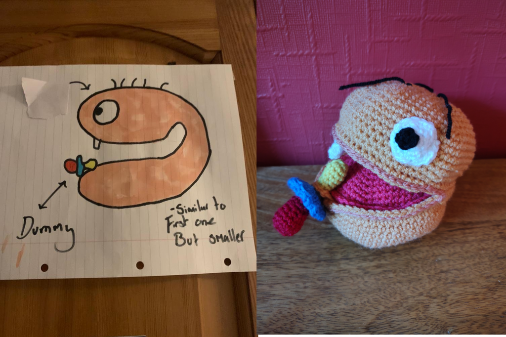 A photo of a peach ball head with dark strands of hair and one tooth in it's top and bottom jaw. It is sucking on a coloured dummy. On the left is the crochet toy of the same