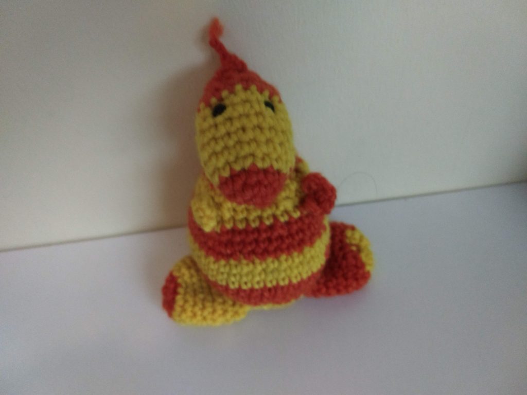 A photo of the crochet toy in yellow and orange stripes