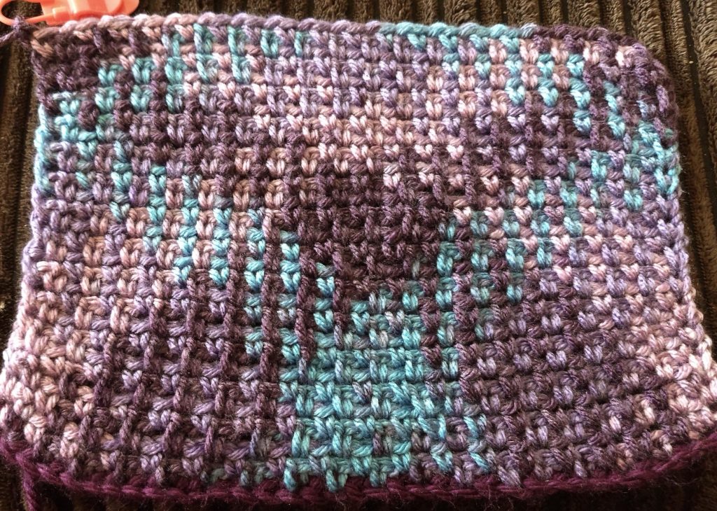 A photo of a crochet piece in the Argyle pattern in shades pf purple and blue