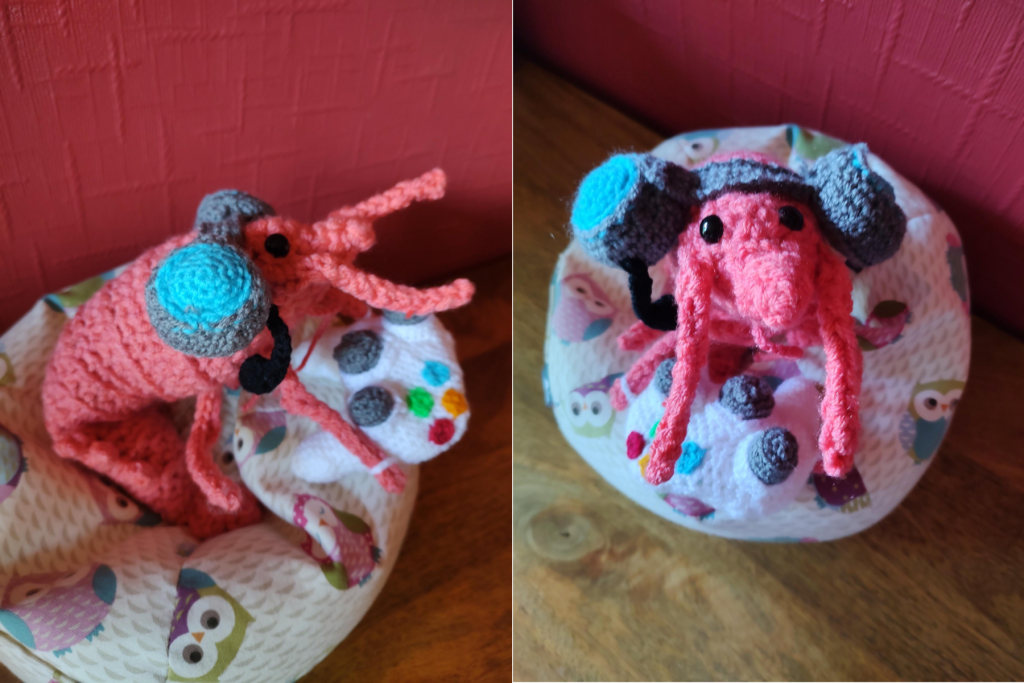 Two photos side by side of a crocheted shrimp which is wearing a blue and grey headset and holding on to a white gaming controller. In the first photo the shrimp if looking to the side as though watching a screen. In the second it is looking up directly at the camera.