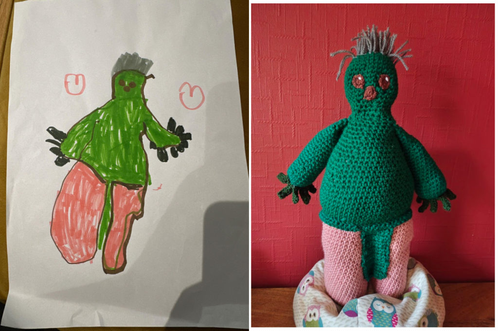 A young child's drawing of a green man with a triangular upper green body and pink legs between which there is a green strip. The goblin, as I call him, has sticky up grey hair and two little round brown eyes and a brown nose/mouth. It has lots of dark green fingers on each hand. Next to the drawing on the right is the crochet toy version standing on a little owl beanbag next to a red wall.